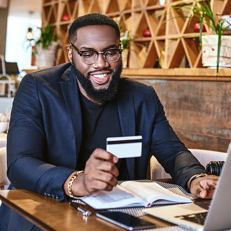 the-time-making-money-should-be-greater-than-the-time-that-you-are-spending-money-smiling-african-american-businessman-holds-his-credit-card-while-resting-in-the-cafe